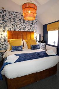 sypialnia z dużym łóżkiem z niebieskimi i żółtymi poduszkami w obiekcie Sea Watch Seafront Holiday House w mieście The Mumbles