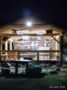 a wooden pavilion with a table in front of it at night at Pensiunea Terra Rosa in Bîltişoara