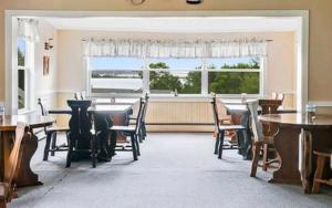 uma sala de jantar com mesas e cadeiras e uma janela em The Island Inn em Ingonish Beach