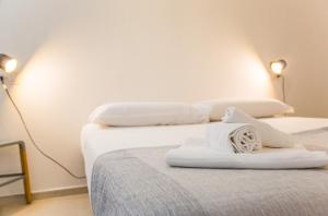 two beds with white sheets and towels on them at Appartamento Oltremare IUNQ5361 in Cala Gonone