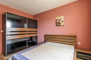 a bedroom with a large bed and a large cabinet at Apartment Sanik in Varna City