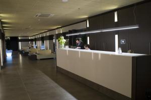 a lobby with two people sitting at a reception counter at Hotel Papi Blau in Malgrat de Mar