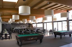a room with pool tables and chairs and windows at Hotel Papi Blau in Malgrat de Mar