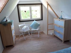 1 Schlafzimmer mit 2 Stühlen, einer Kommode und einem Fenster in der Unterkunft Villa Sonja in Kurort Altenberg