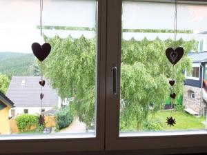 zwei Herzen, die von einem Fenster mit Blick auf einen Hof hängen in der Unterkunft Villa Sonja in Kurort Altenberg