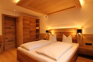 1 dormitorio con 1 cama grande con sábanas blancas en Gästehaus Bliem, en Mayrhofen