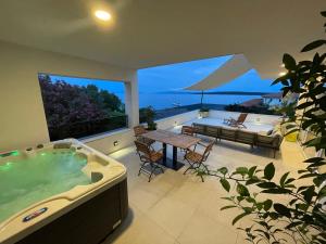 a large jacuzzi tub in a house with a table at Exclusive 2 Bedroom Seafront Suite with jacuzzi in Zavala