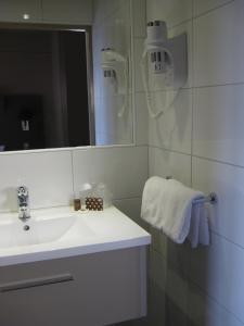 a white bathroom with a sink and a mirror at Moka Hotel in Niort