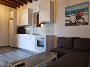 a living room with a couch and a kitchen at Kamaroporta Luxury Apartments in Ayios Theodhoros