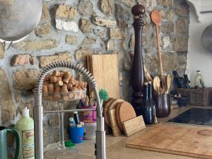 a kitchen counter with a basket of bread and a stone wall at Villa St. Georges in Piran