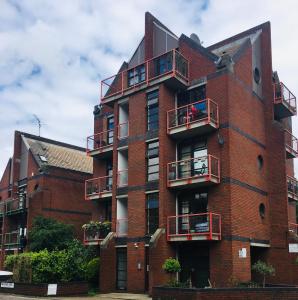 un edificio de ladrillo rojo con balcones. en One-bedroom Rotherhithe/Bermondsey flat, Central London, UK en Londres