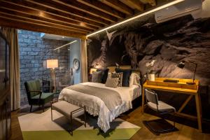 a bedroom with a bed and a rock wall at Casa Cien Hilos in San Miguel de Allende