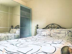 1 dormitorio con 2 camas y un espejo grande en One-bedroom Rotherhithe/Bermondsey flat, Central London, UK en Londres