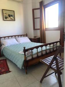 - une chambre avec un lit avec un cadre en bois et une fenêtre dans l'établissement Pericles Traditional Cretan Home, à Stavrokhórion