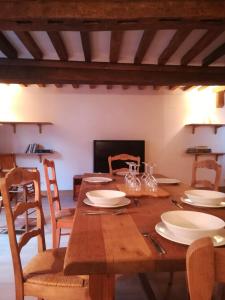 a wooden table with plates and glasses on it at Duplex avec terrasse lumineux proche vieux bassin in Honfleur +6 photos