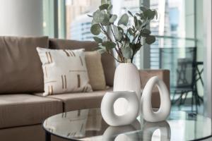 a white vase sitting on a glass table in a living room at GuestReady - Stunning View from Every Room in Dubai