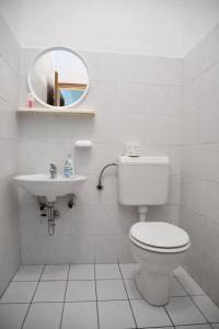 uma casa de banho branca com um WC e um lavatório em Apartmani Zdenka em Banjol