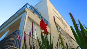 a building with a fence and flowers in front of it at Casari rooms & apartments in Split