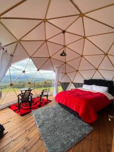 een slaapkamer in een tent met een bed en een tafel bij Glamping hermoso amanecer in Guatavita