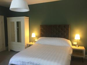 a bedroom with a large white bed with two lamps at Kings B&B in South Molton
