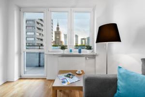 een woonkamer met een bank en een raam bij Sleep4you Apartamenty Centrum in Warschau