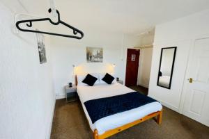 um quarto com uma cama num quarto branco em OYO The Sun Hotel em Skegness