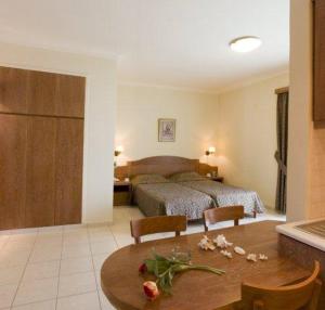 een slaapkamer met een bed en een tafel met bloemen erop bij Mike Studios & Apartments in Maleme