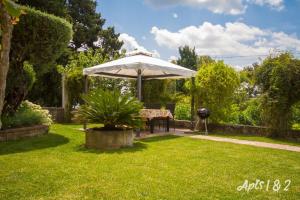 a table and an umbrella in a yard at Apartments Kolenc in Portorož +24 photos