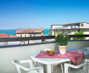 a table and chairs on a balcony with a view of the ocean at Residenza Nobel Appartamenti in Rimini