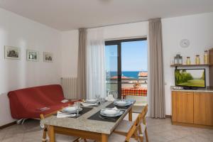a living room with a table and a couch and a television at Residenza Nobel Appartamenti in Rimini