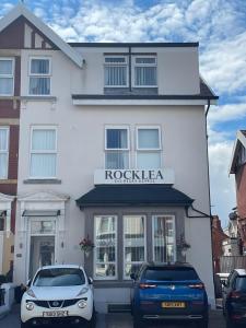 ブラックプールにあるRocklea Hotelの前に車が駐車されている白い建物