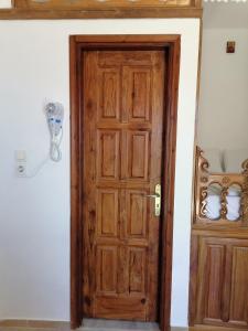 una puerta de madera abierta en una habitación blanca con en KALLIOPIS STUDIO, en Olympos