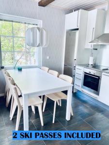 a white kitchen with a white table and chairs at Levin Rölli 3 in Levi