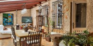 patio con mesa, sillas y TV en La Casa del Obispo en Almagro