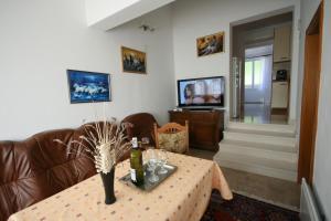 ein Wohnzimmer mit einem Tisch und einem Sofa in der Unterkunft Apartments Ivancevic in Korčula