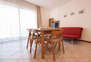 a dining room with a table and chairs and a couch at Residenza Nobel Appartamenti in Rimini