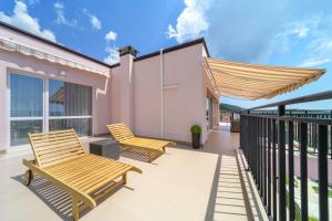 un patio con 2 sillas de madera en el balcón en Vinnie View, en Varna