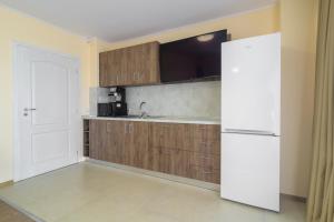 Una cocina con gabinetes de madera y un refrigerador blanco. en Vinnie View, en Varna