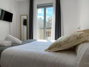 托莱多Barrio Rey的一张带枕头和窗户的白色床