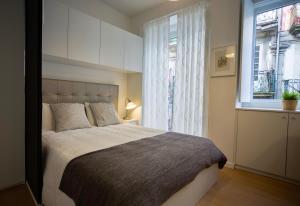 - une chambre avec un grand lit et une fenêtre dans l'établissement D&S - Porto São Bento Apartments II, à Porto