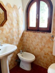 a bathroom with a sink and a toilet and a window at Il Forno Di Renzo in Castiglione della Pescaia