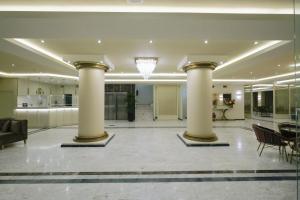 a lobby with columns and a kitchen in a building at Hotel Diamantidis in Myrina
