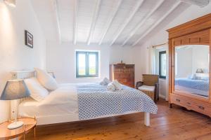 a white bedroom with a bed and a mirror at Quinta da Alfazema in Quelfes +32 photos
