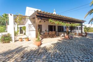 a house with a patio with chairs in front of it at Quinta da Alfazema in Quelfes