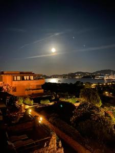 a view of a building at night with the moon at Appartamento Portisco sul Mare in Olbia