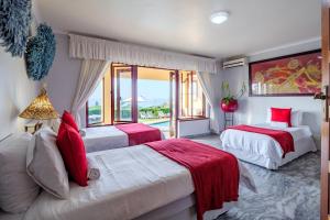 a bedroom with two beds with red pillows and a window at Umhlanga Beach House in Durban +56 photos