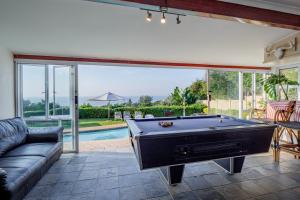 a living room with a pool table and a couch at Umhlanga Beach House in Durban