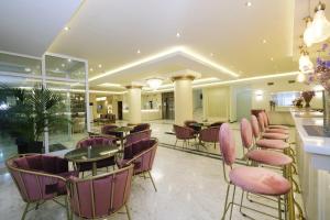 a restaurant with purple chairs and tables and a bar at Hotel Diamantidis in Myrina