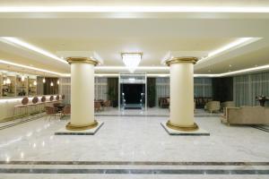 a lobby of a hotel with columns and chairs at Hotel Diamantidis in Myrina