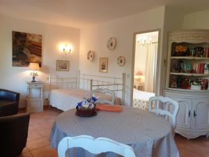 sypialnia z 2 łóżkami, stołem i krzesłami w obiekcie Résidence A Merula w Calvi